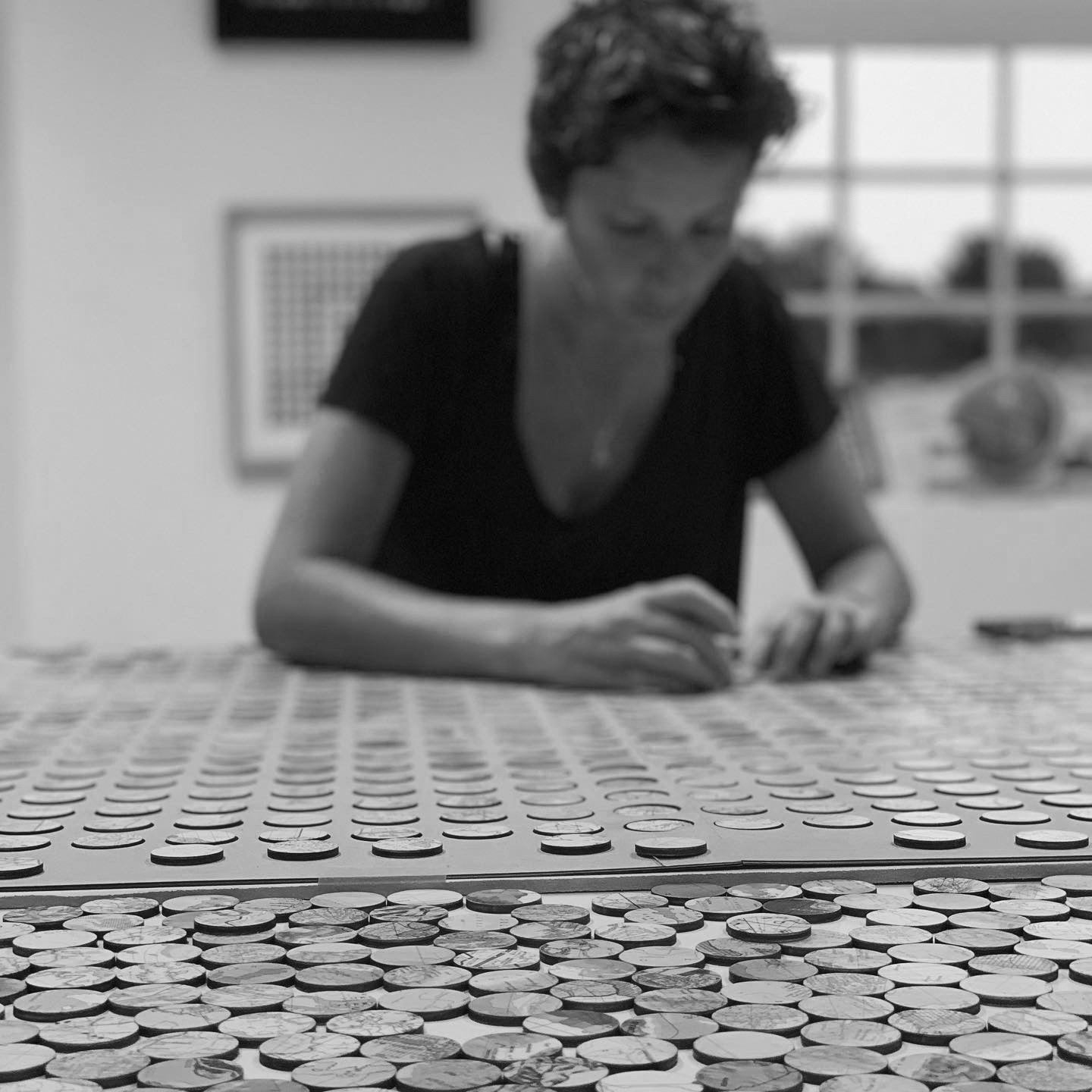 Amelia Coward in her studio working on a map dots artwork