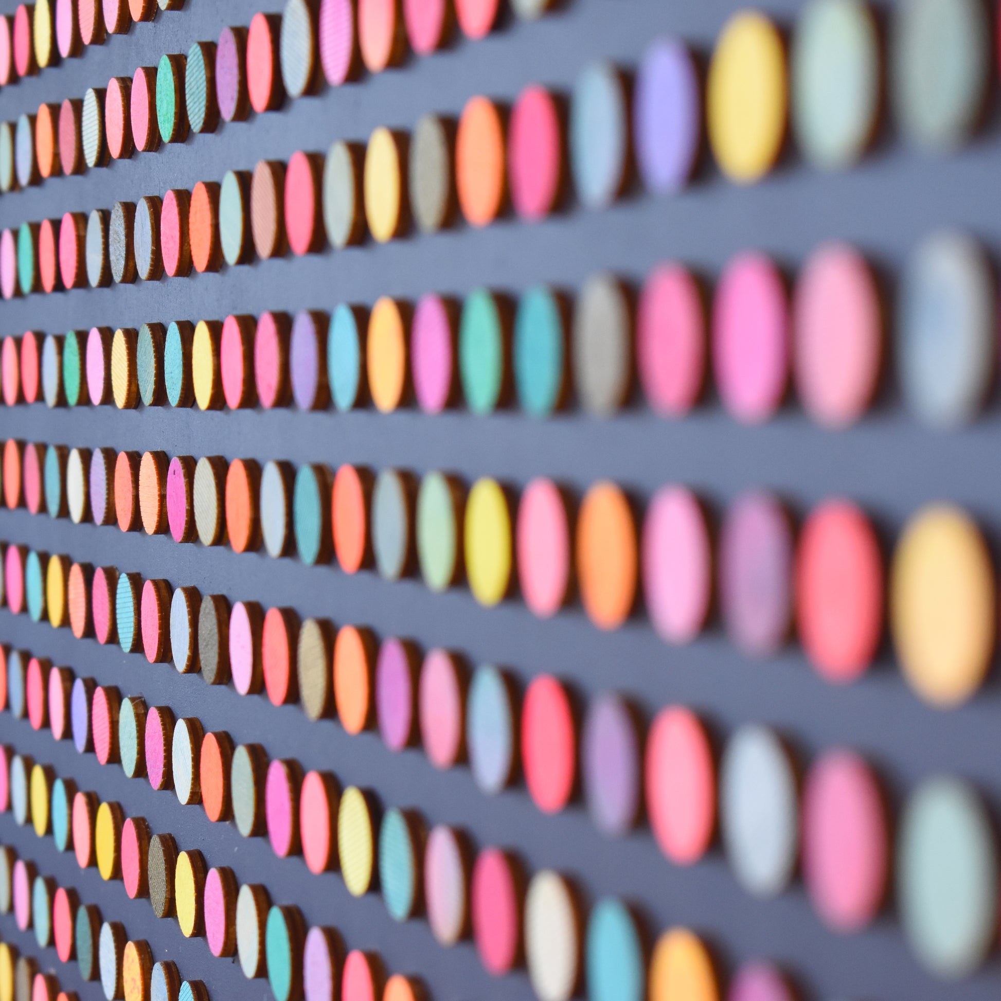 detail of painted dot collage on black by Amelia Coward